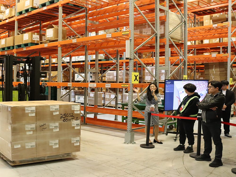 Warehouse staff reviewing stock handling on the warehouse floor