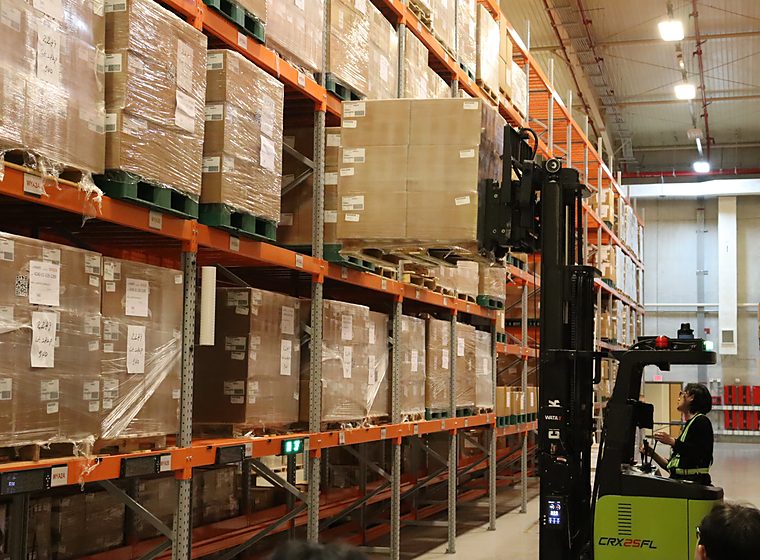 A forklift moving palletised freight through a warehouse