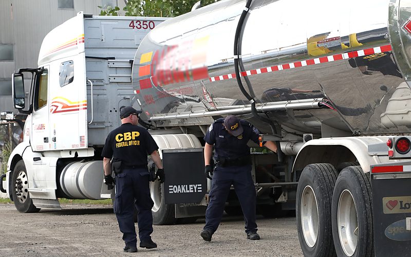 Customs officers inspecting a truck at a border port of entry
