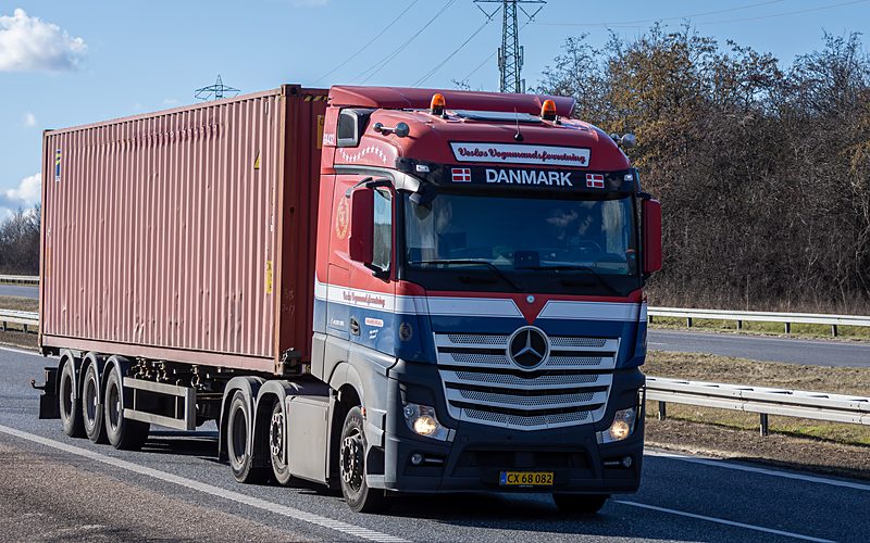 A transport truck carrying a shipping container on the highway